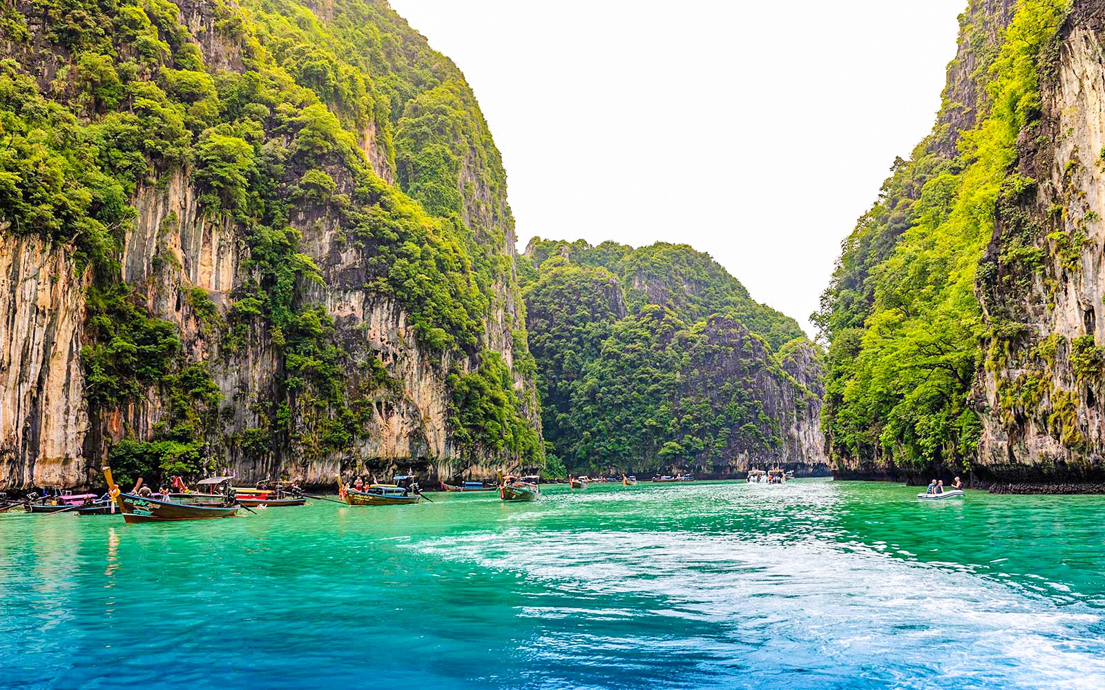 皮勒泻湖的绿松石水域中漂浮着长尾船,四周是石灰岩悬崖,位于甲米。