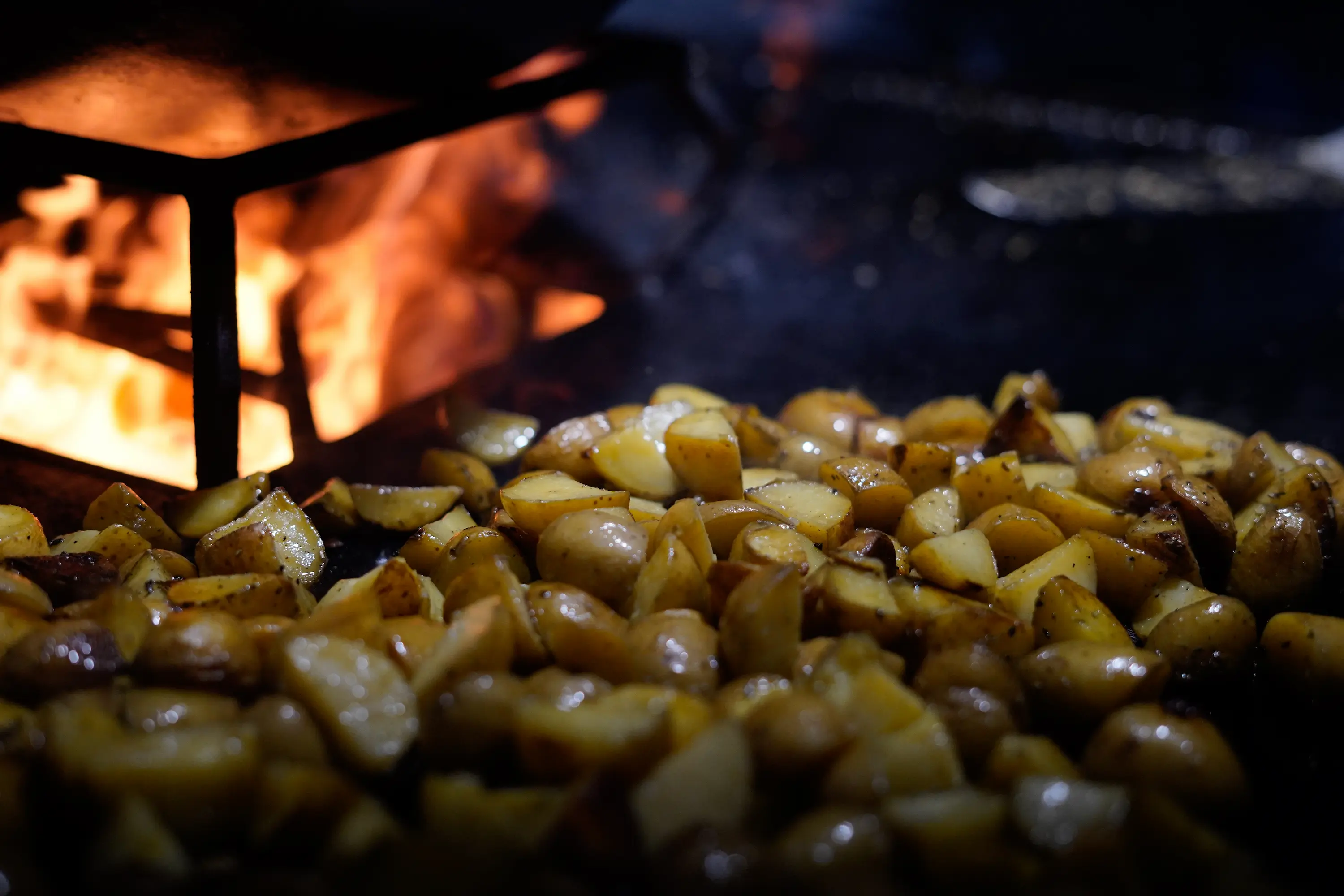     Bratkartoffeln werden über offenem Feuer frisch zubereitet