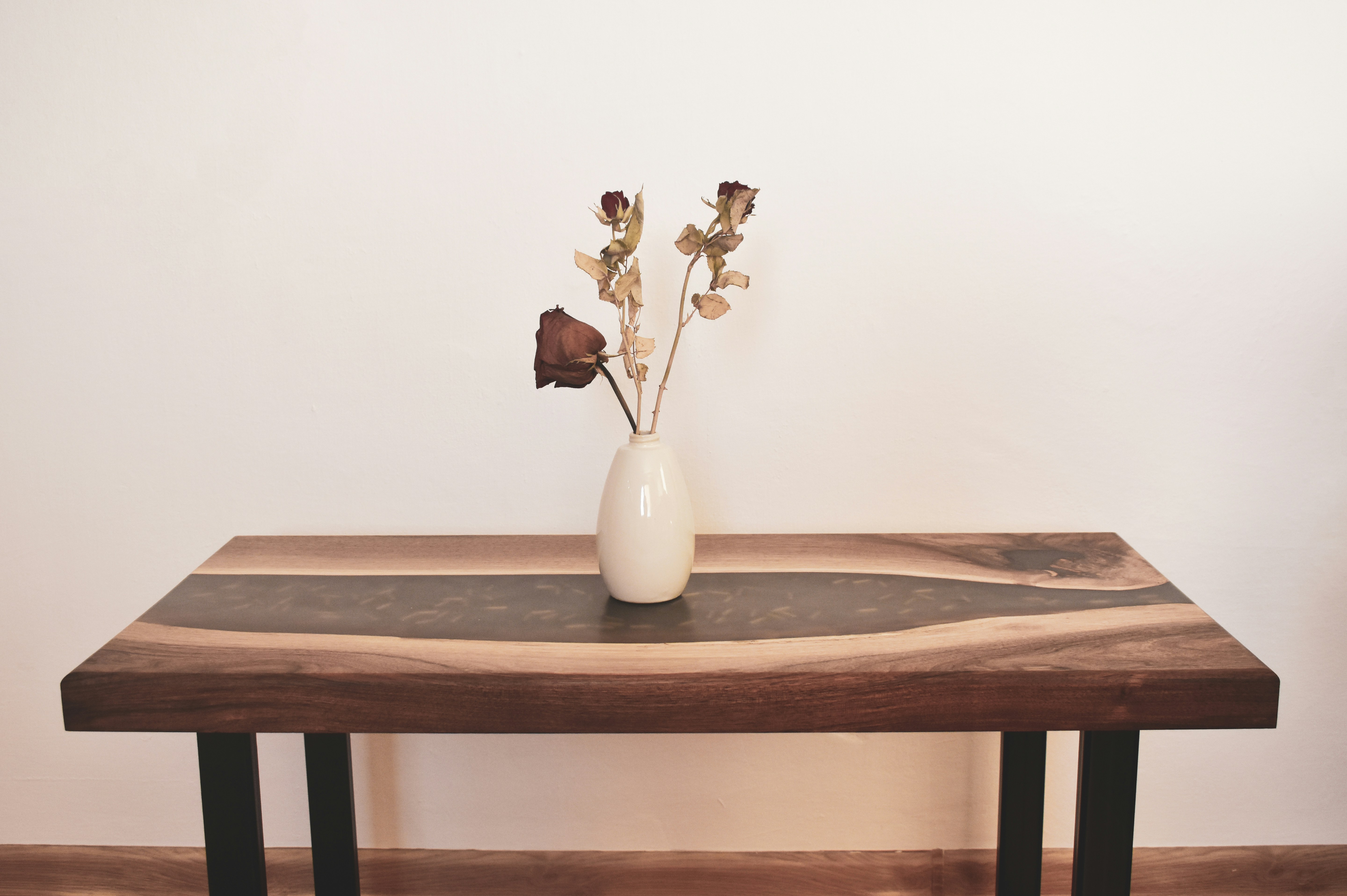 a wooden table with a vase of flowers on top of it