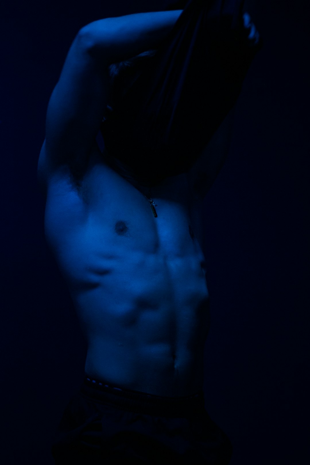 Grayscale artistic shot of a muscular male physique focusing on hypertrophy and muscle mass.