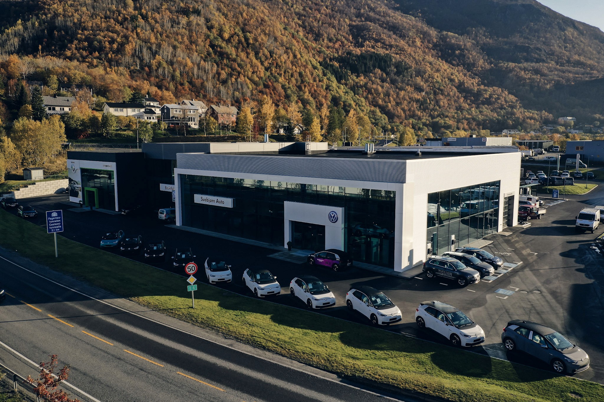 Svebjørn Autos bilforhandler i Narvik med biler utenfor og høstfarget fjellside bak