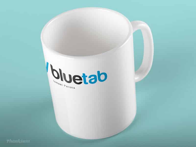 Taza de cerámica blanca con logo "bluetab" sobre fondo azul.