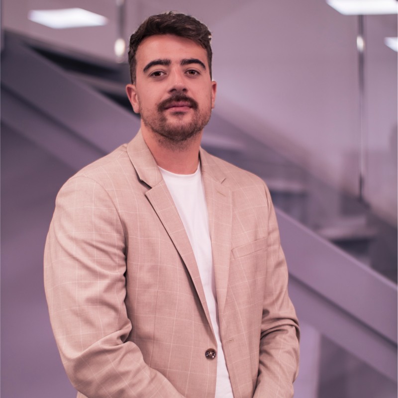 Uomo in blazer sorridente in un moderno ambiente d'ufficio.