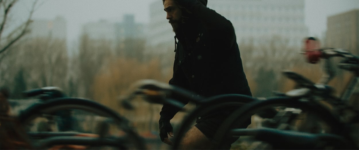 Guy skateboarding in a moody rainy setting