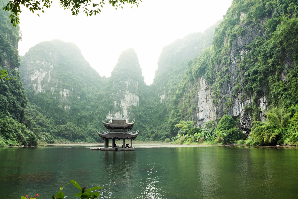 Limestone karsts rising from calm waters with a traditional pagoda in northern Vietnam