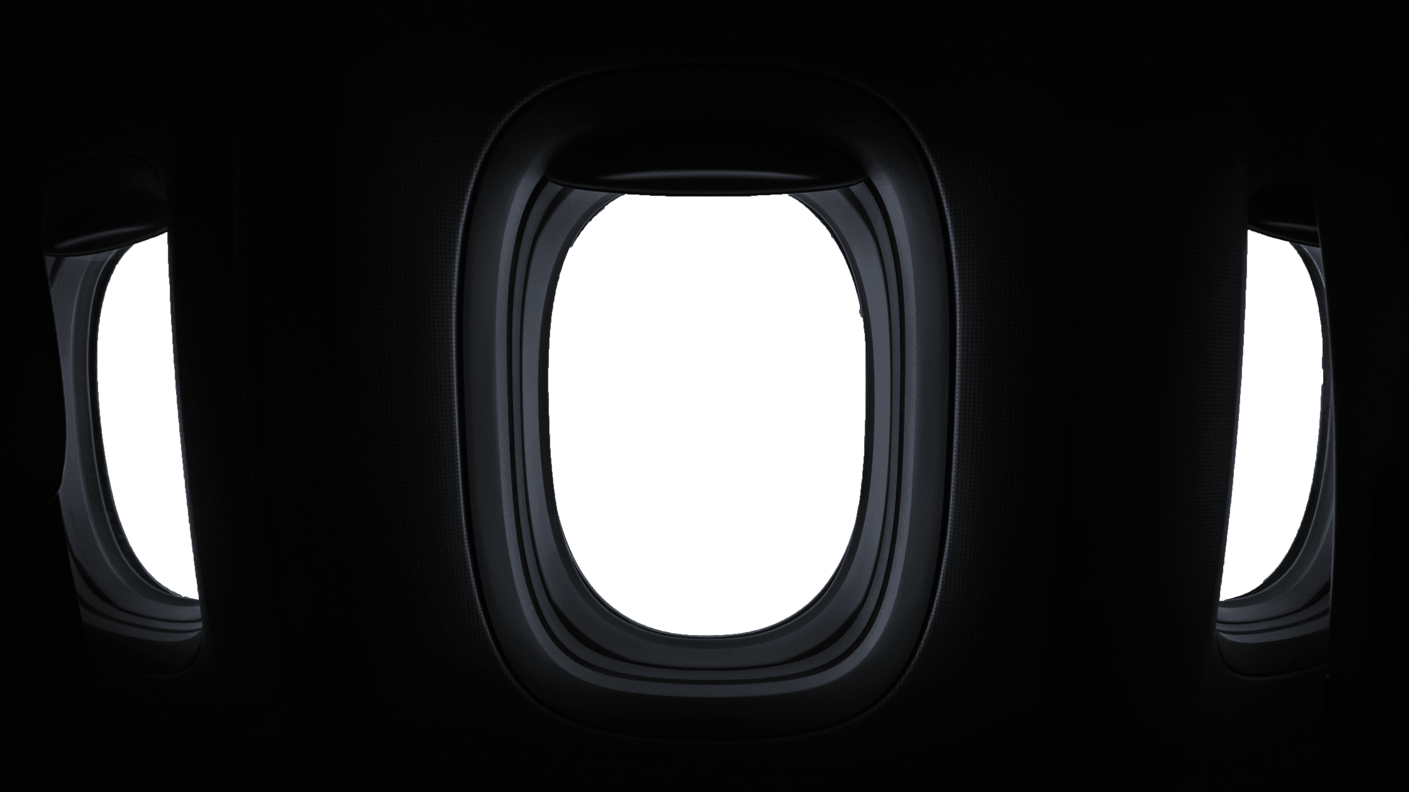 Drei ovale Fenster einer Kabine mit Blick nach draußen. Dunkelgraue Fensterrahmen, blaugraue Fenster.