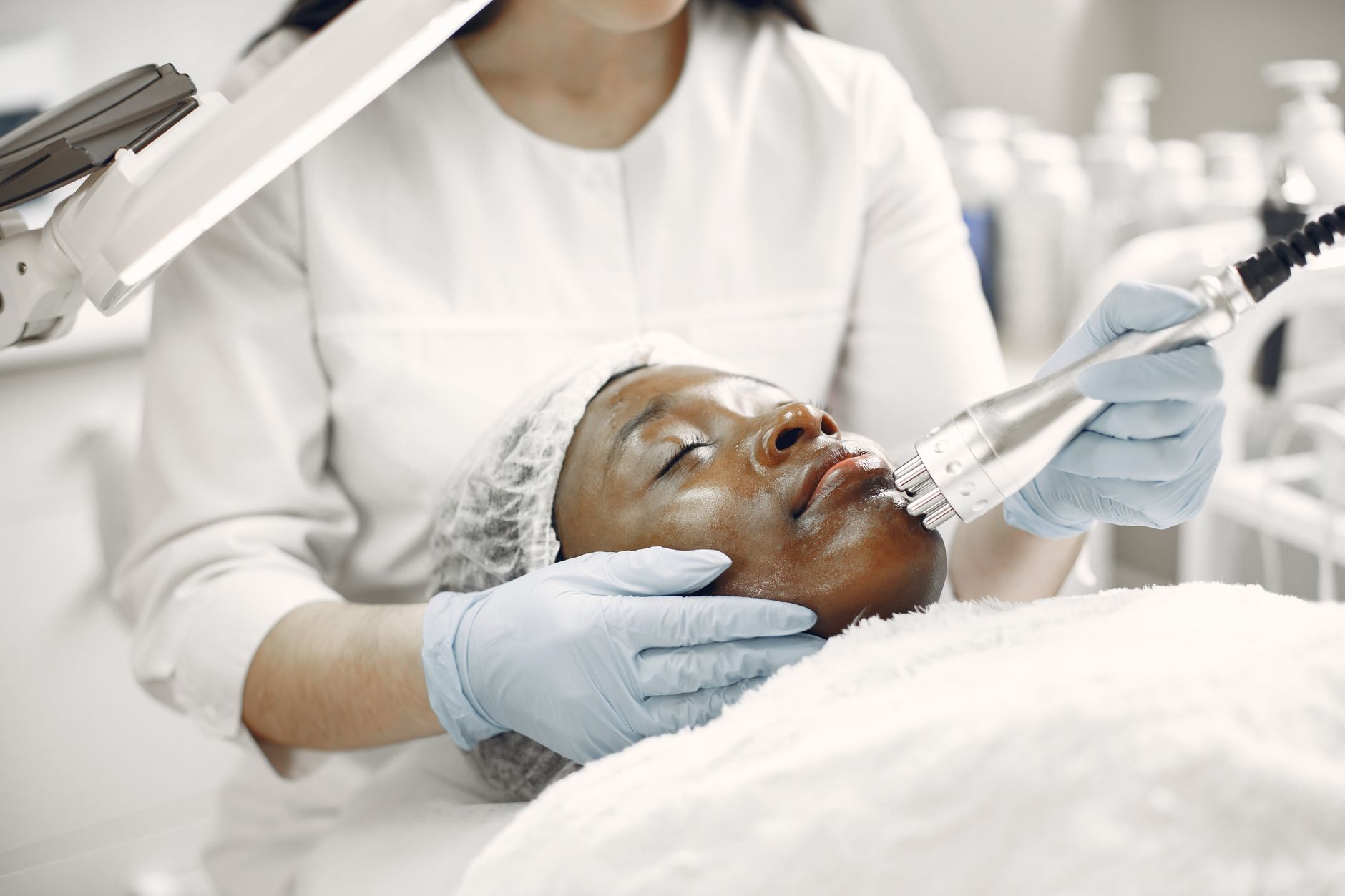 Aesthetic provider using specialized laser system on client face for pigment reduction