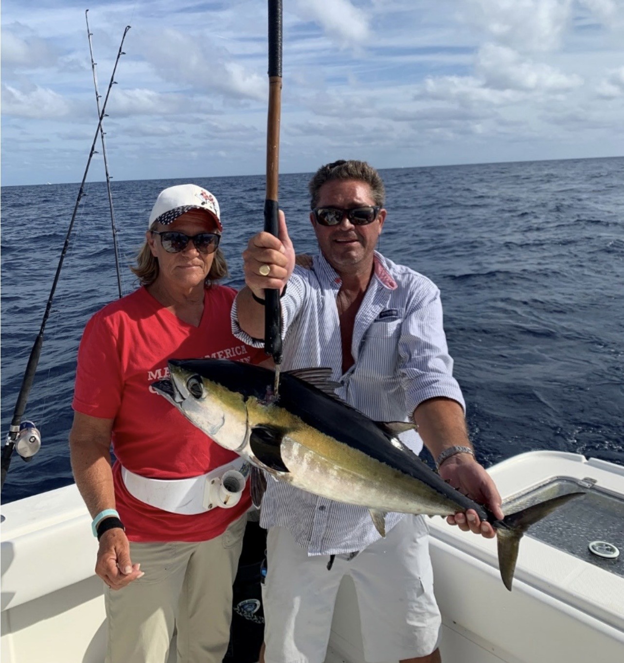 Roger and Tess Romine on a fishing boat holding a freshly caught tuna
