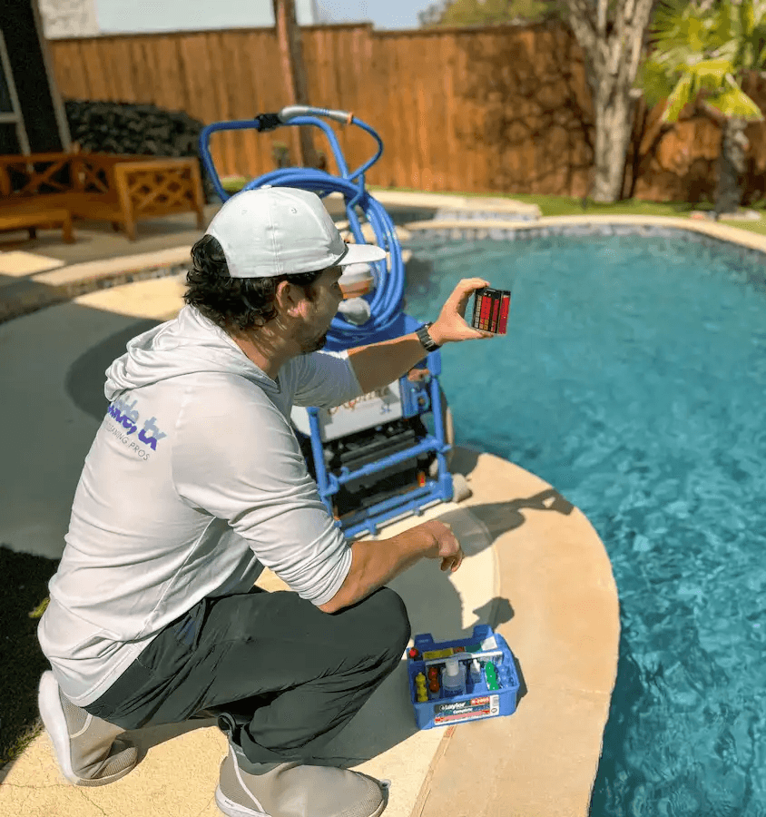 Poolside, TX certified pool professional checking pool chemical balance in yard of Plano, TX homeowner