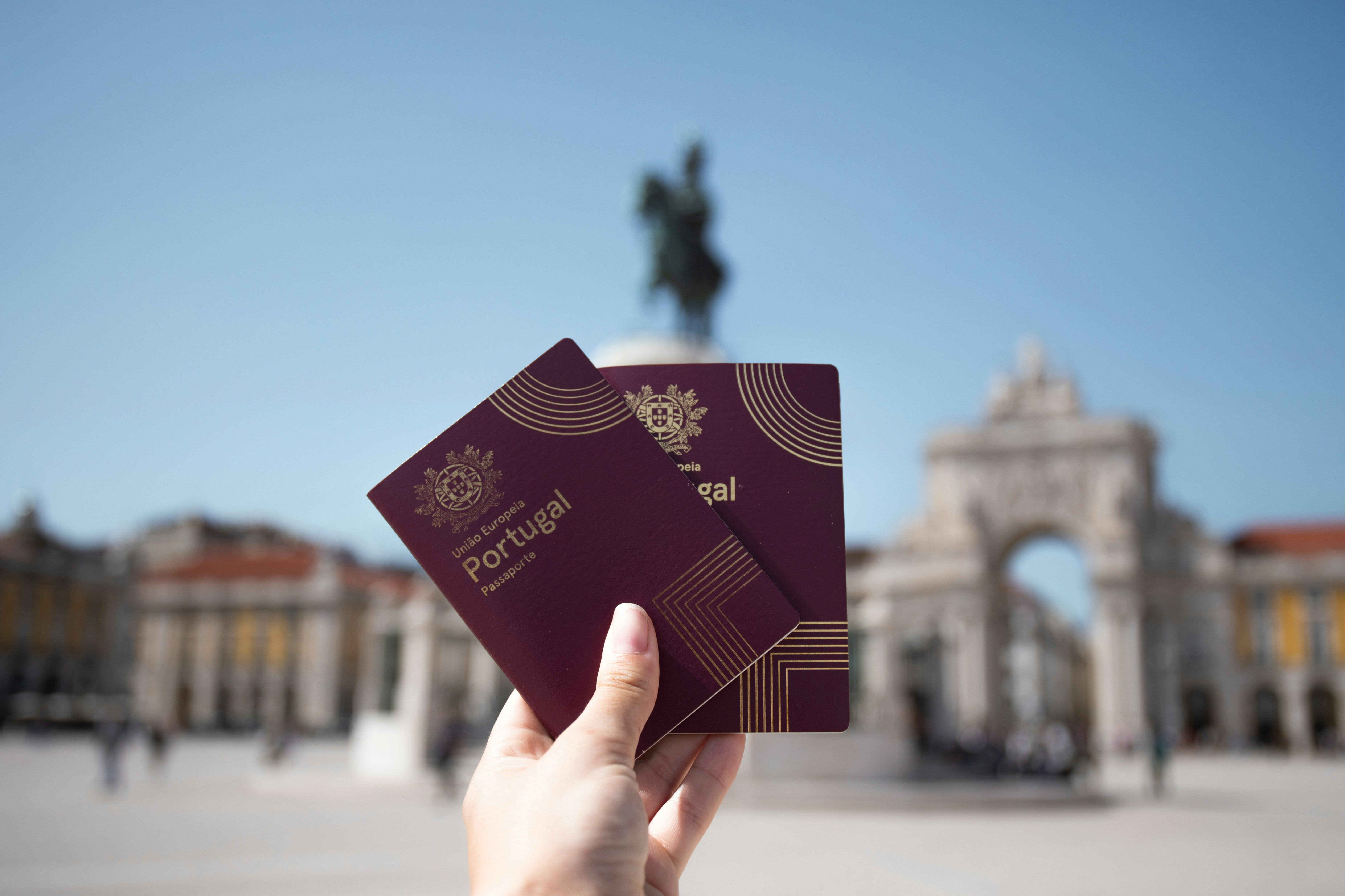 Holding portuguese passports with a blurred background.