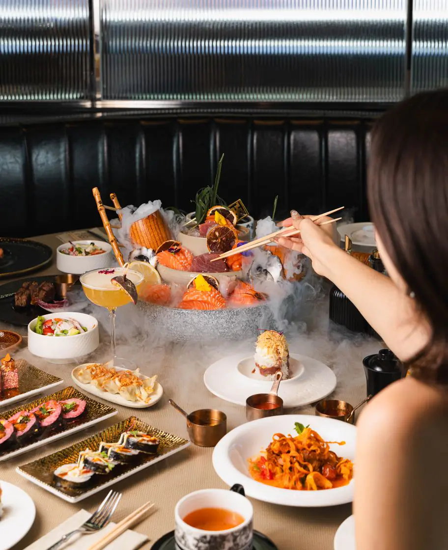 A sashimi platter wreathed in smoke, served at a table at Sushi Club Pontault-Combault