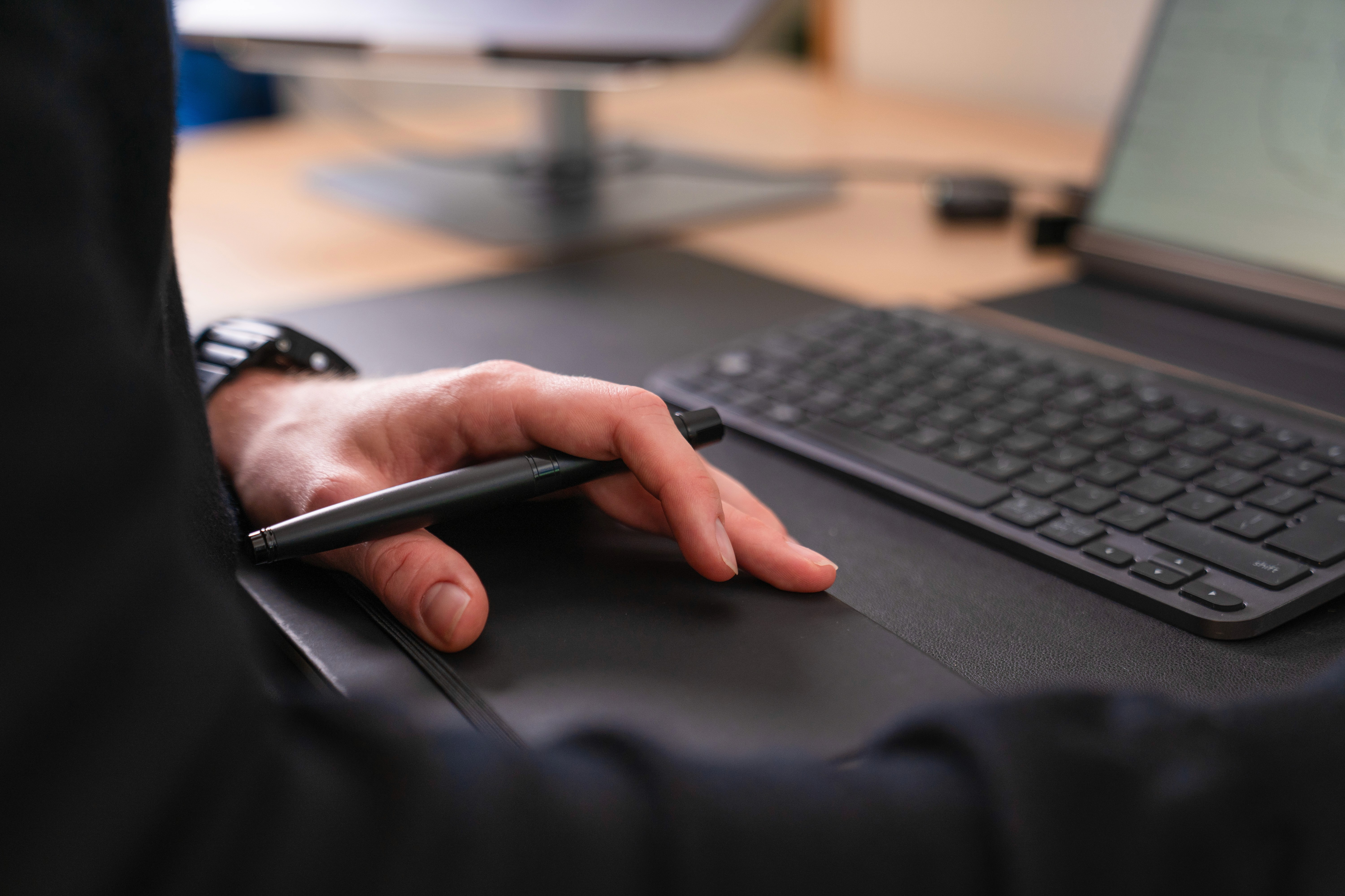 Person holding a pen and notebook