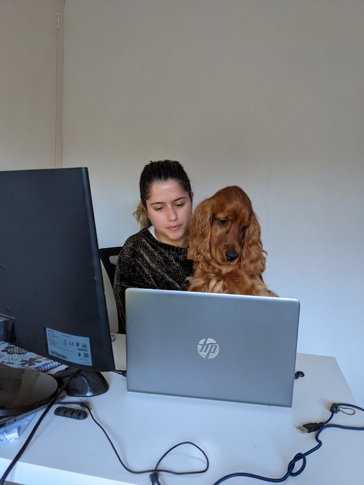 Black and white photo of two people looking at a computer screen with papers on wall