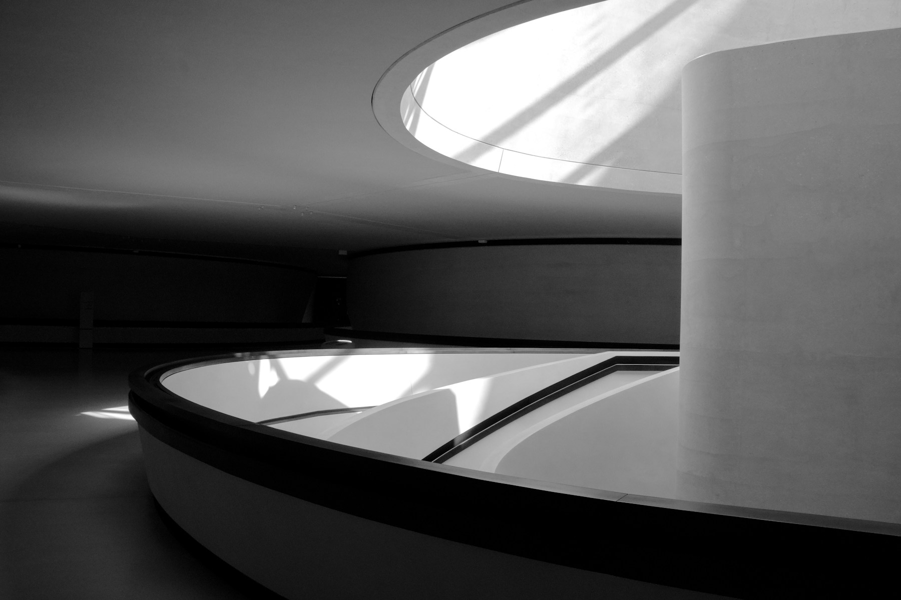Curved interior ramp washed with light from a circular skylight