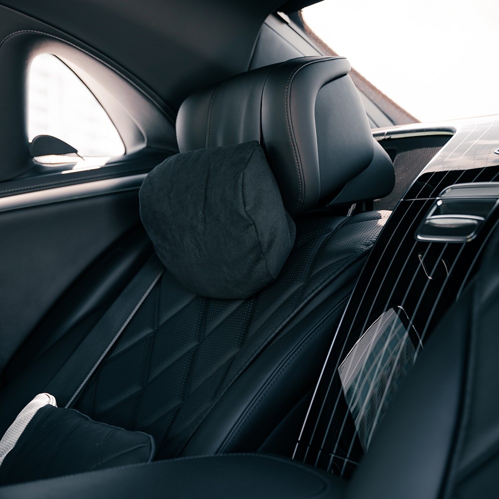 Executive rear seating area of the Mercedes-Maybach S580, showcasing unparalleled comfort and diamond-stitched leather.