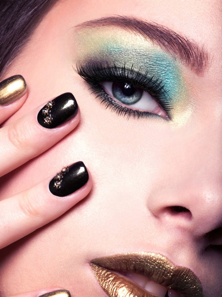 makeup model with green eyeshadow and dark nail polish