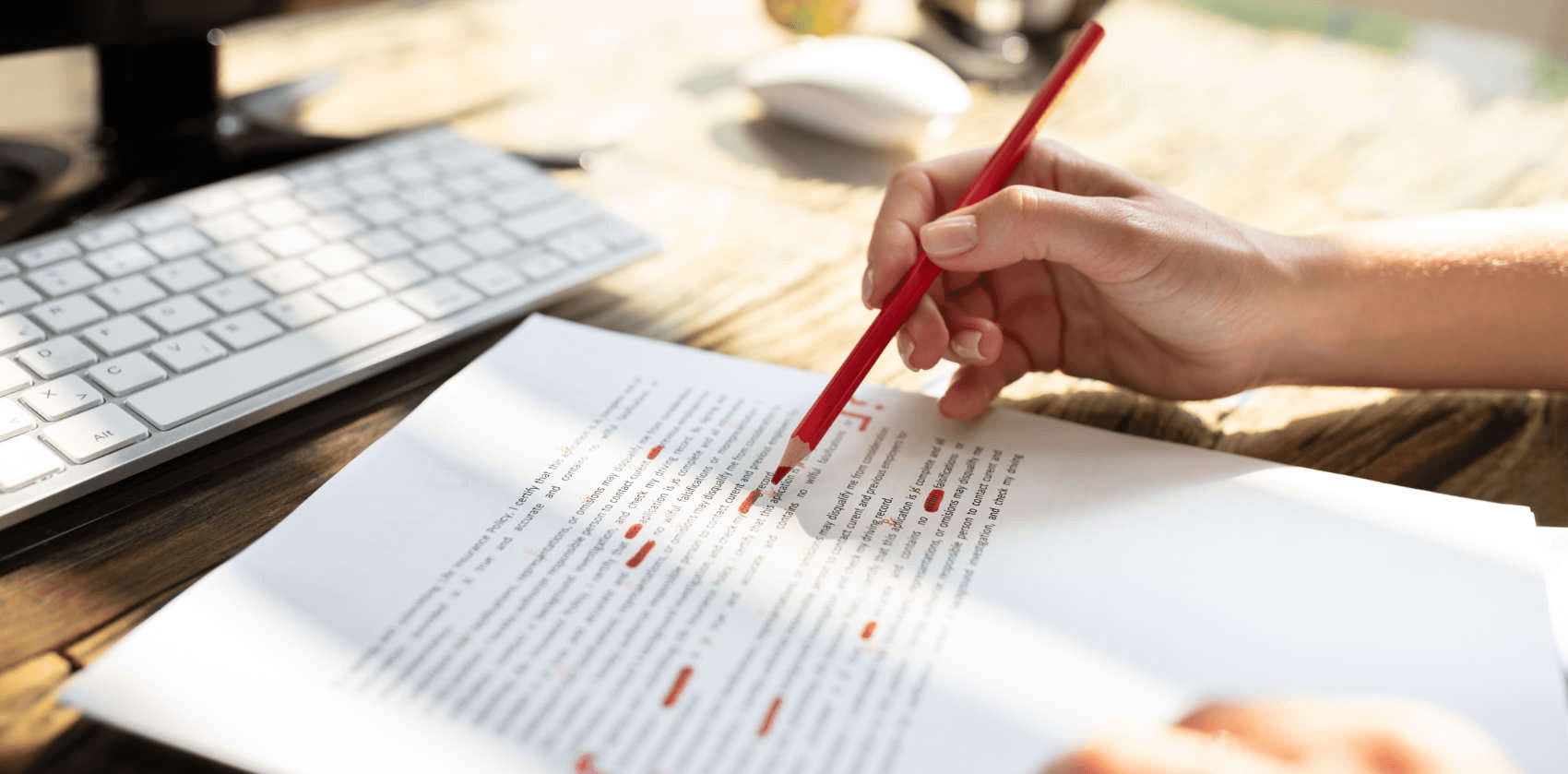 Person editing document with red pencil - Best Software For Automating Document Templates