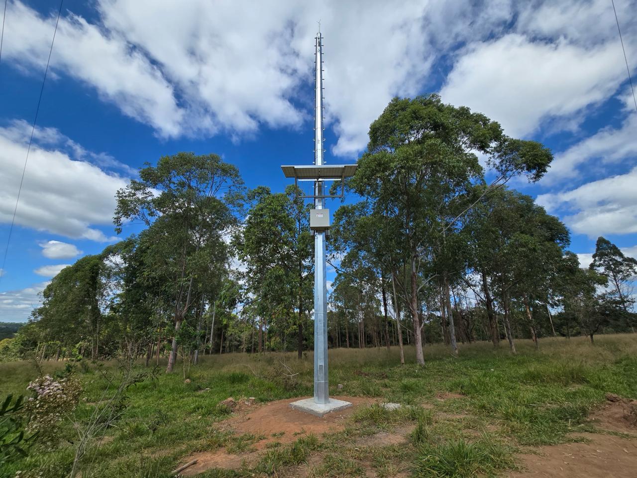 A winding road cuts through rocky terrain, surrounded by patches of green grass and illuminated by sunlight.