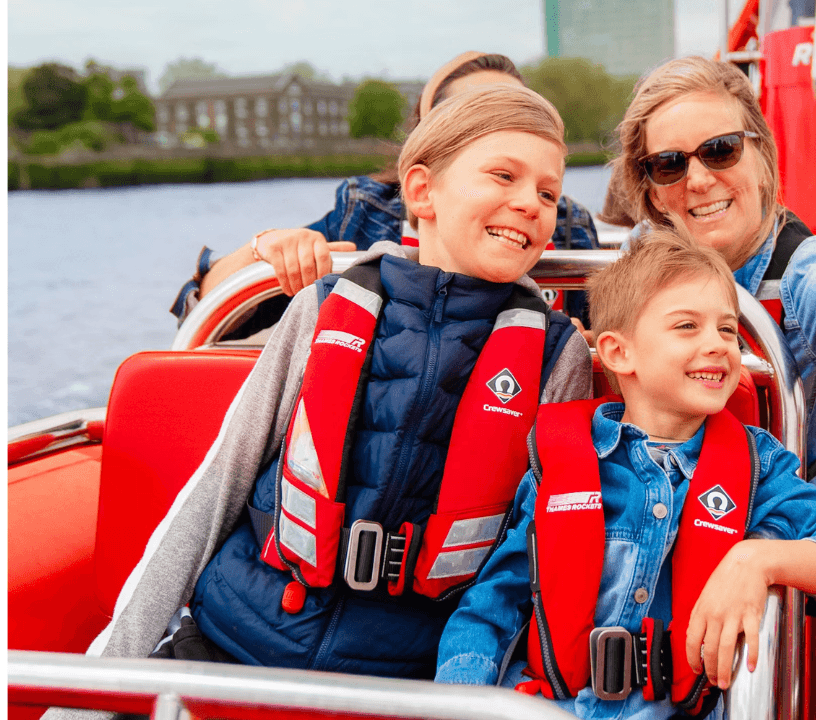 Thames Rockets Speedboat Experience: A Family of 4, 2 adults and 2 children all wearing life vests smile as they ride the Thames Rockets