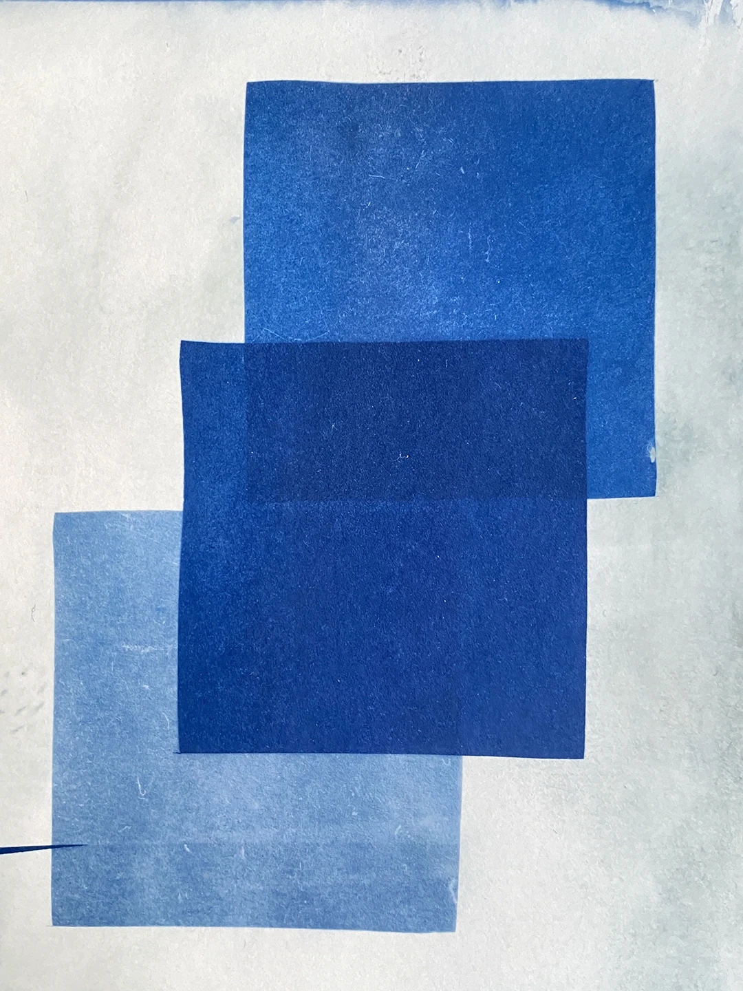 Abstrakte blaue Strukturen auf Papier, erzeugt durch unterschiedliche Belichtungsstärken und UV-Licht im Cyanotypie-Prozess.