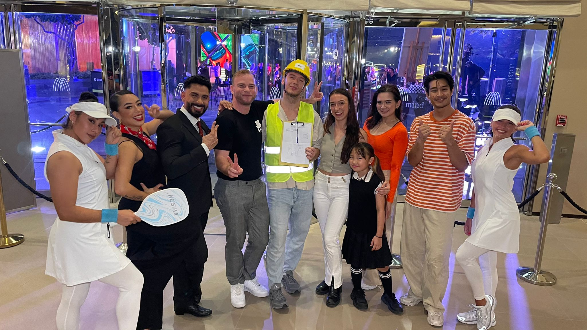 Flashmob cast for smart car reveal in Dubai featuring lifestyle character performers in tennis costumes, business styling, construction worker costume, and family themed outfits