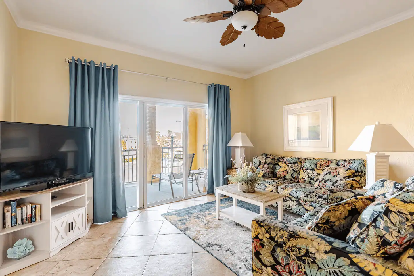 Living room of a waterfront Treasure Island condo with seating and sliding doors opening to a private balcony