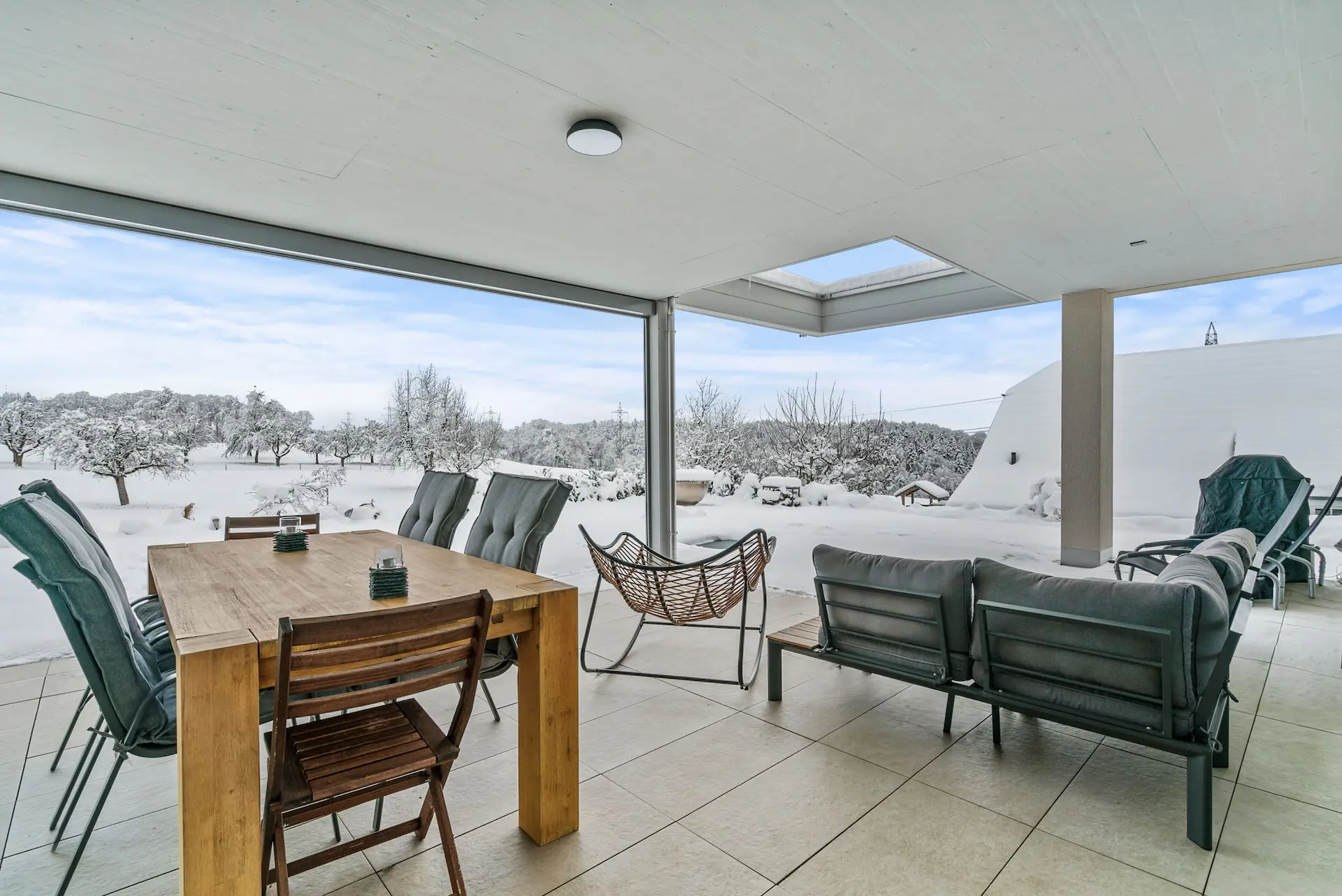 Gemütliche Sitzlounge und Essbereich mit einer verschneiten Aussicht in Schlierbach