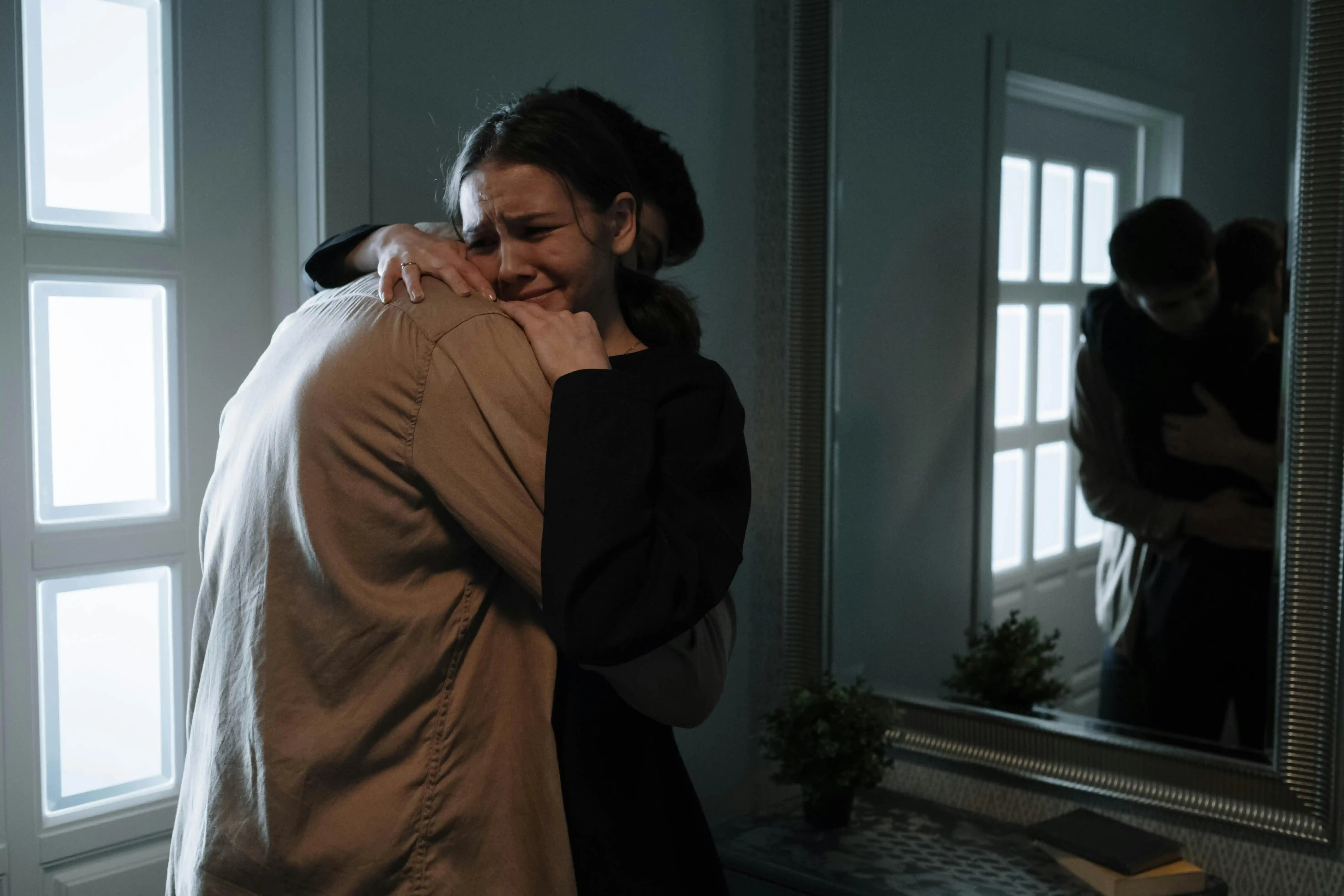 woman and man hugging each other crying