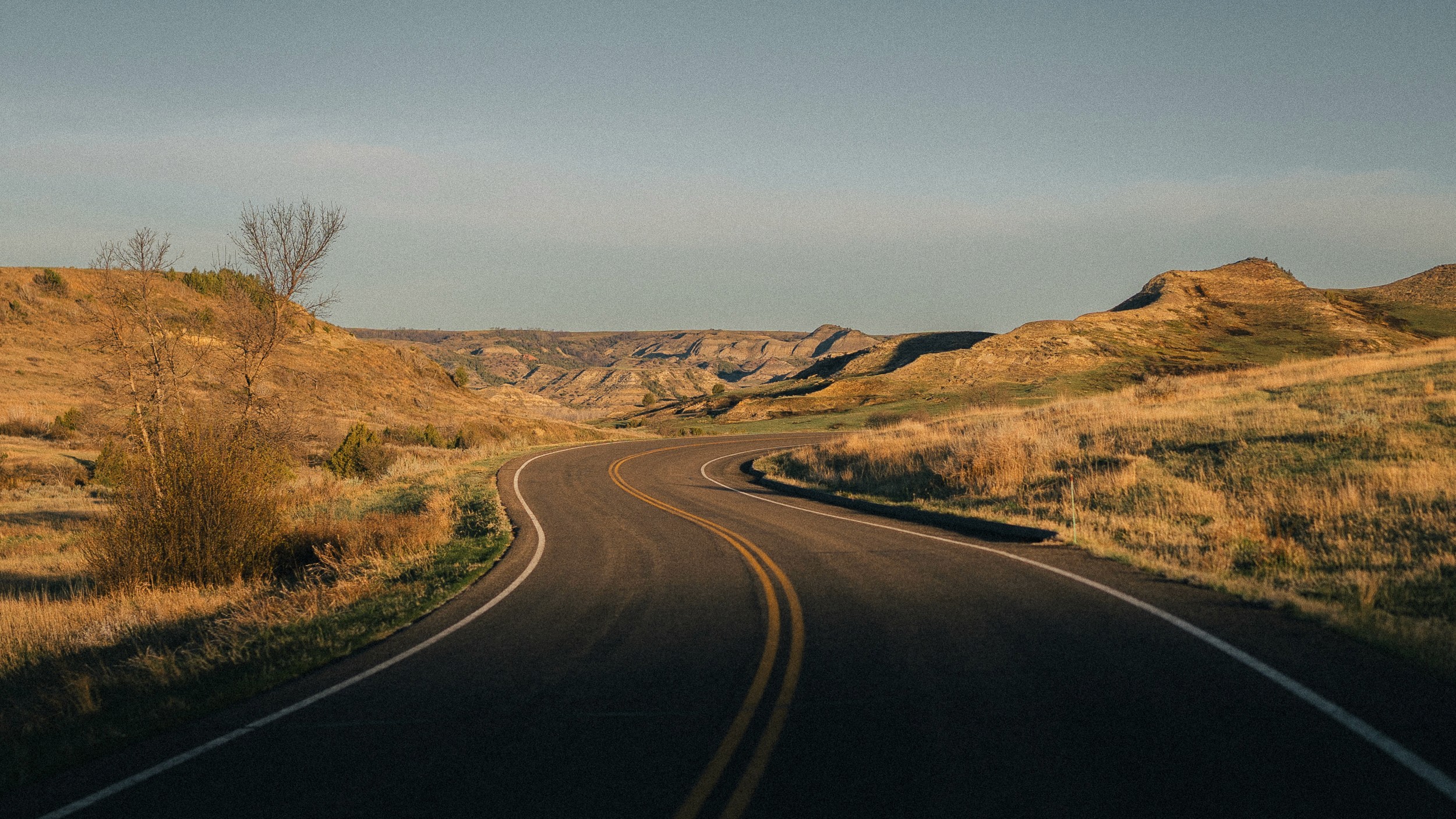 Silhouette of a rocky island against a golden sunset over the ocean