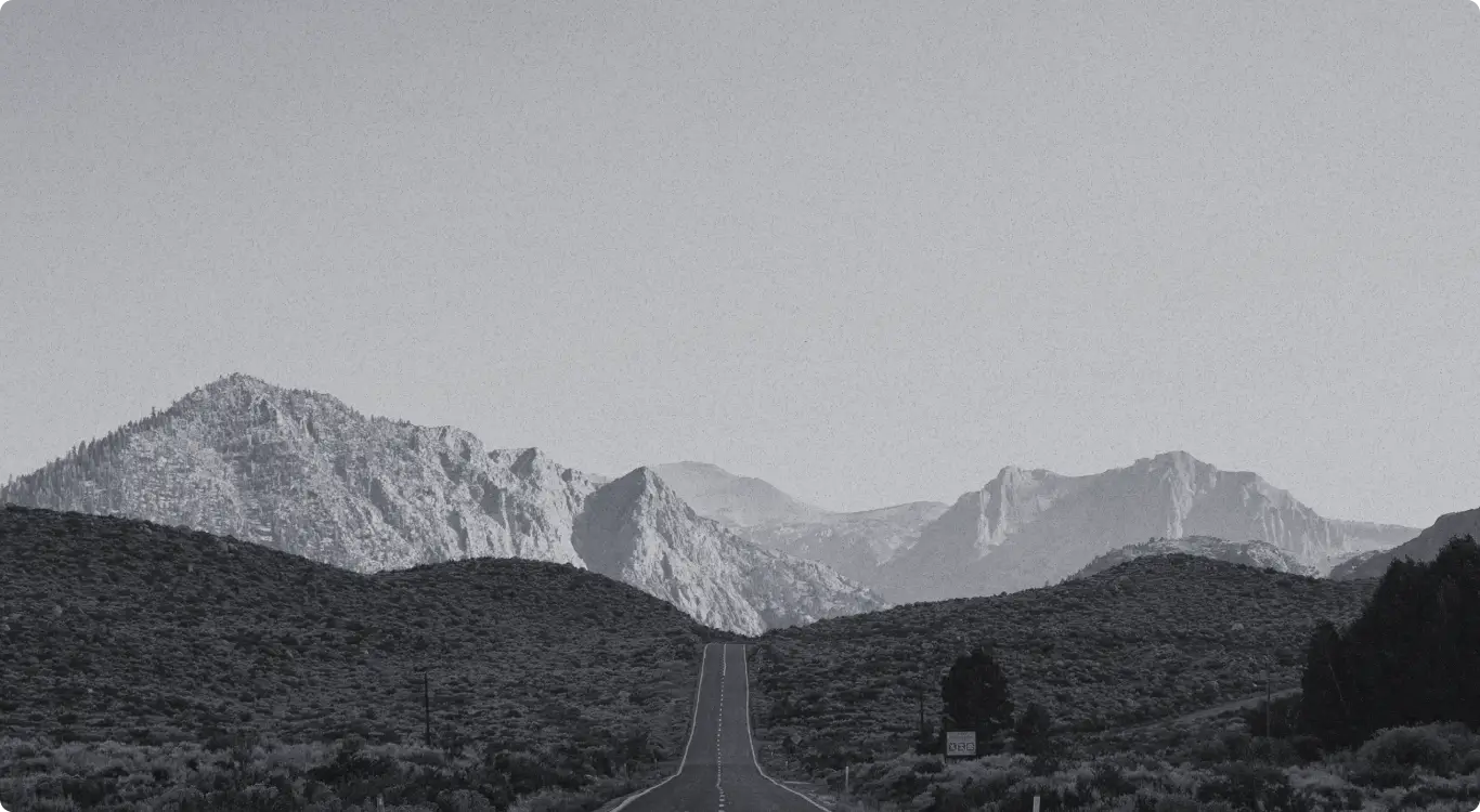 Landscape of an open road leading into a mountain range