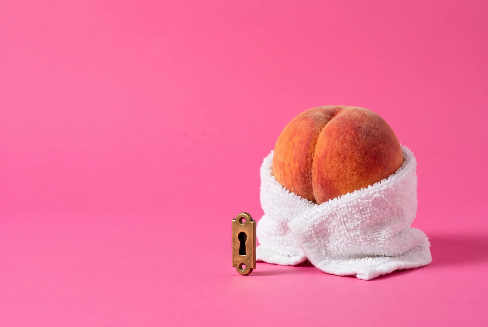 A peach wrapped in a white towel behind a brass keyhole plate, privacy in Accountable2You vs Covenant Eyes