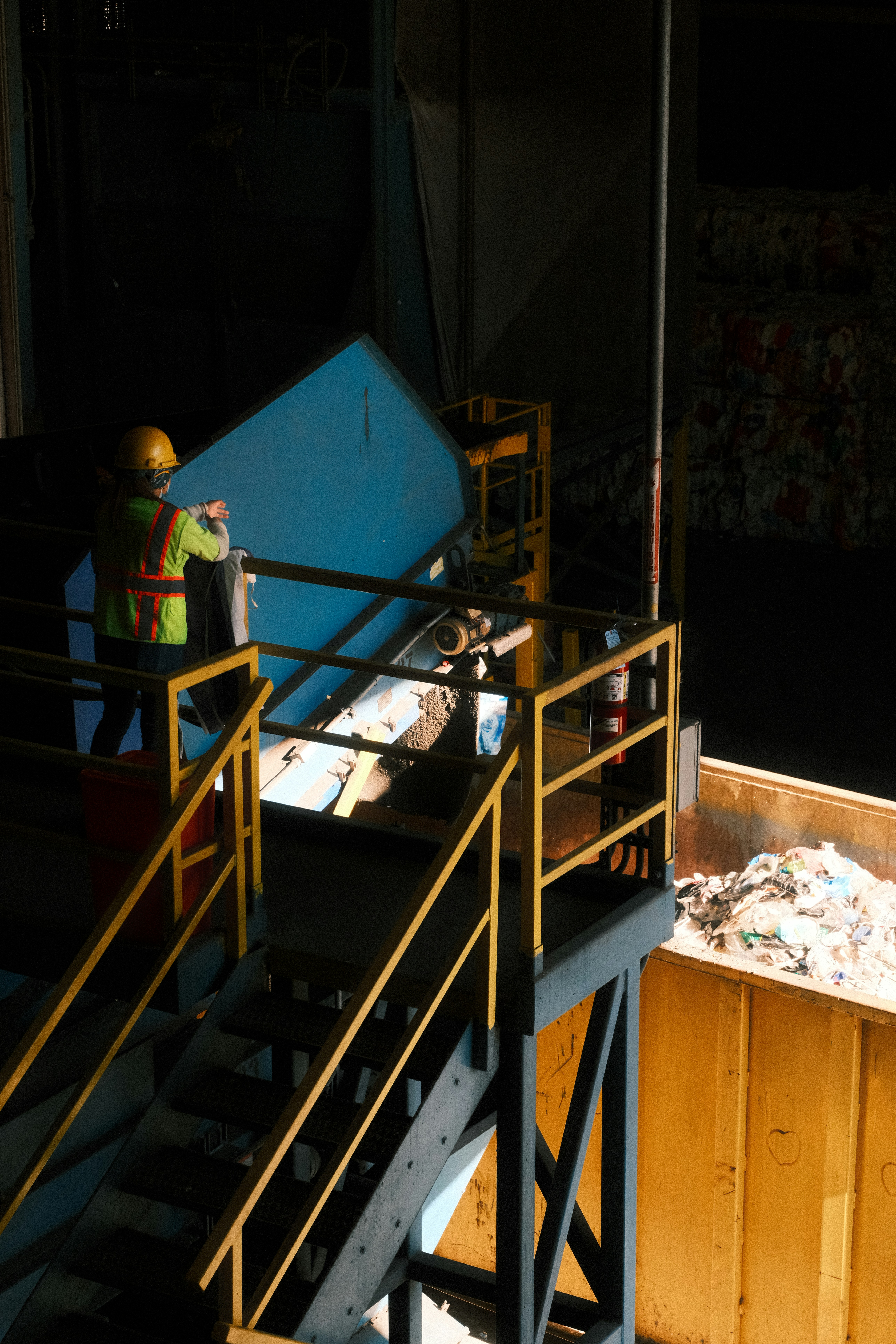Worker feeding blue material onto conveyor belt