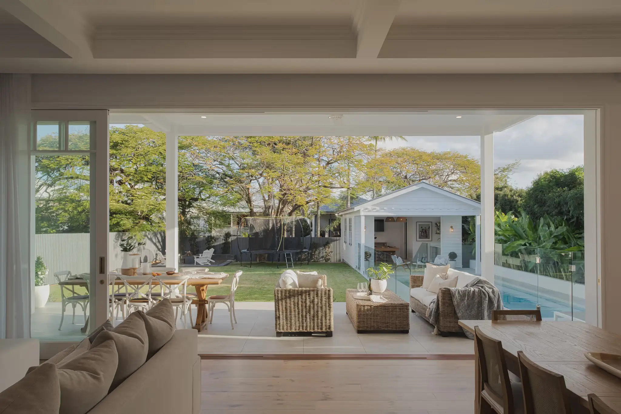 Sliding doors blend the indoor and outdoor areas with a view of the backyard and pool