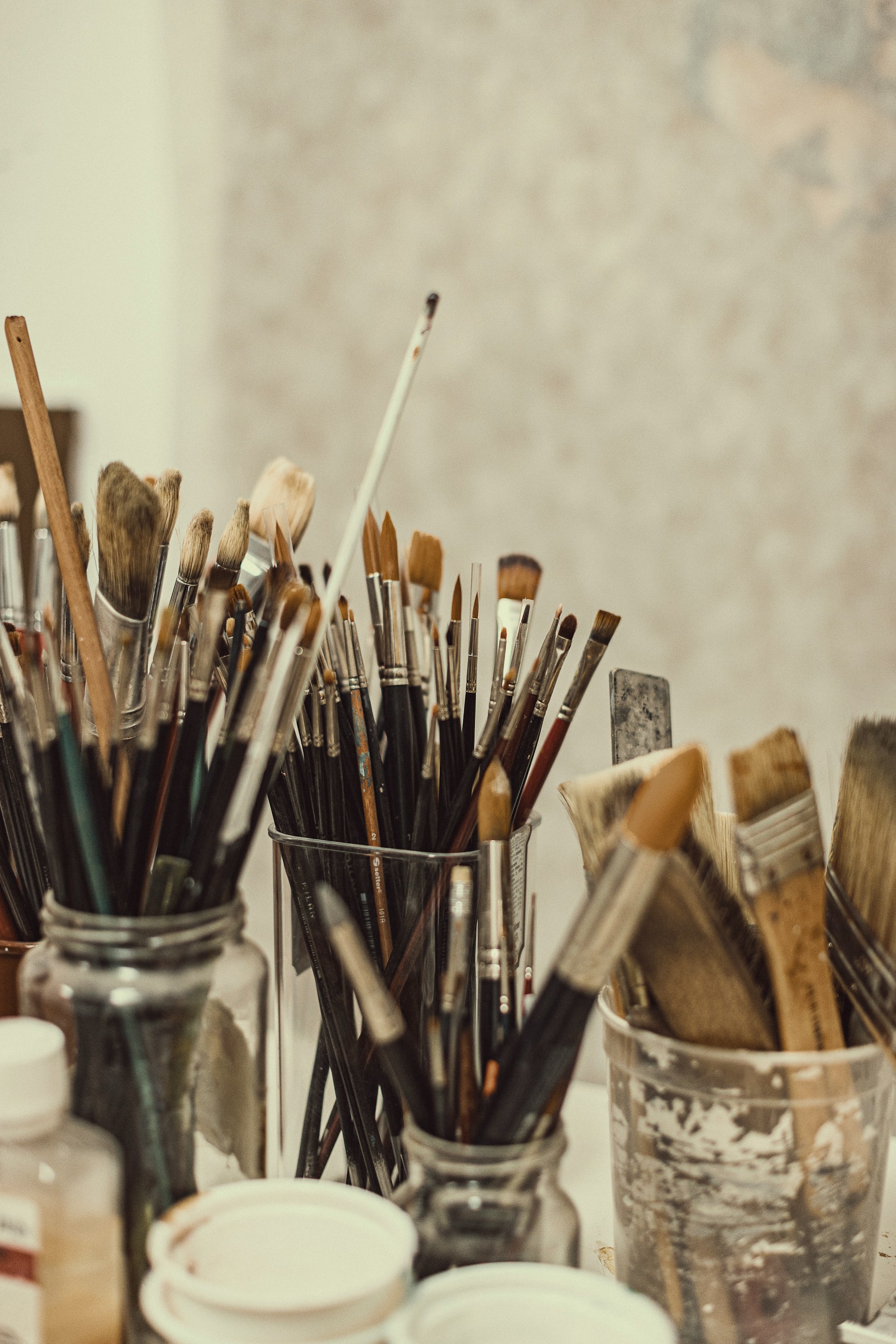 Jars of well-used paintbrushes