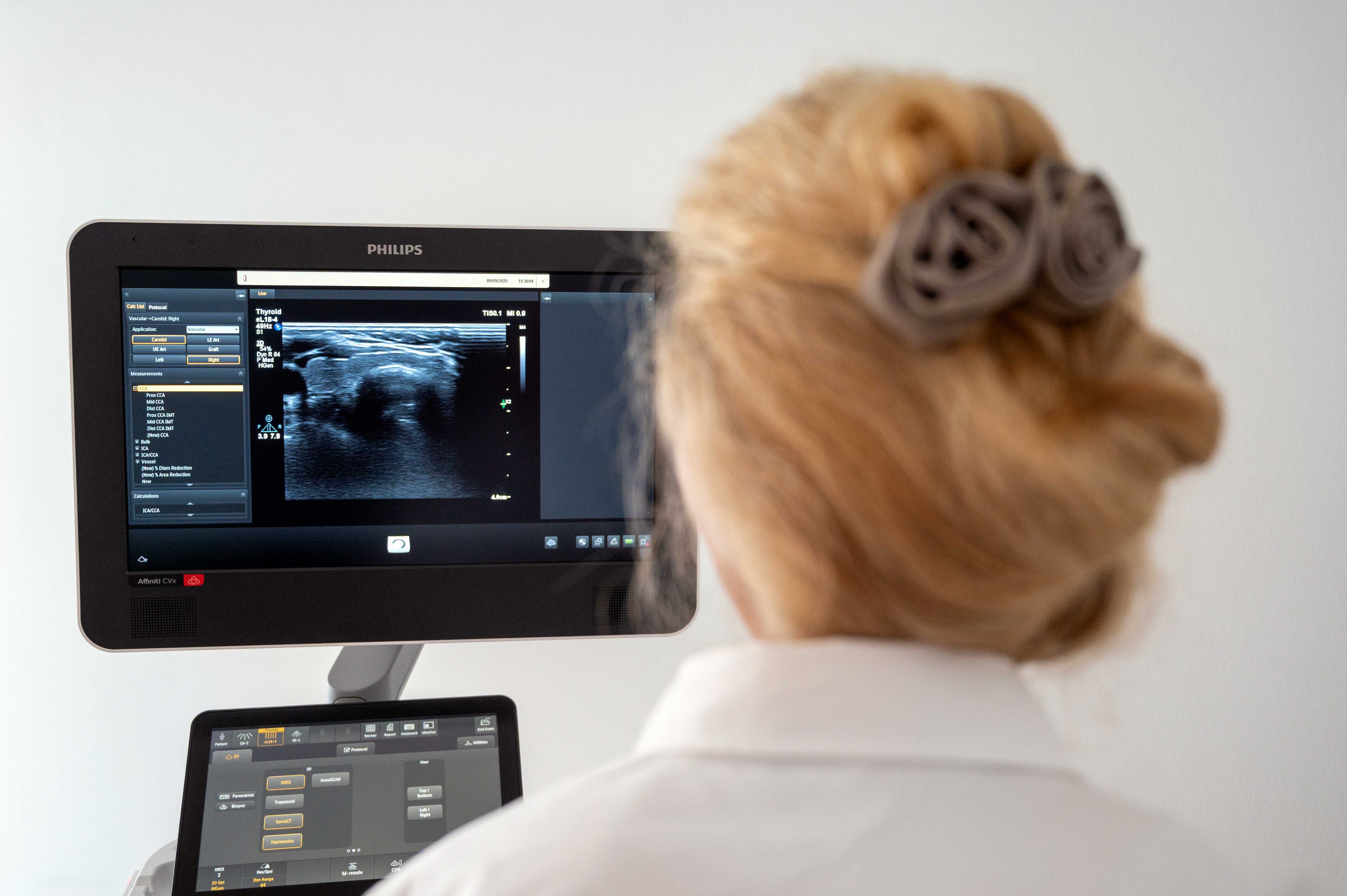A male doctor examining a woman in an eye exam machine to assess their vision.