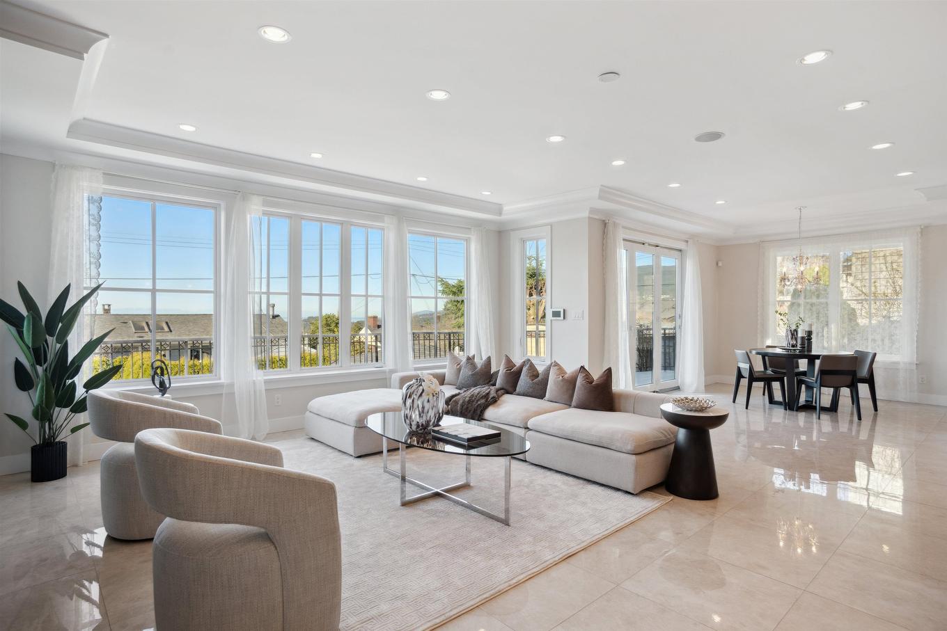 Bright, modern living room with large windows, stylish furniture, and a view of the outdoors.