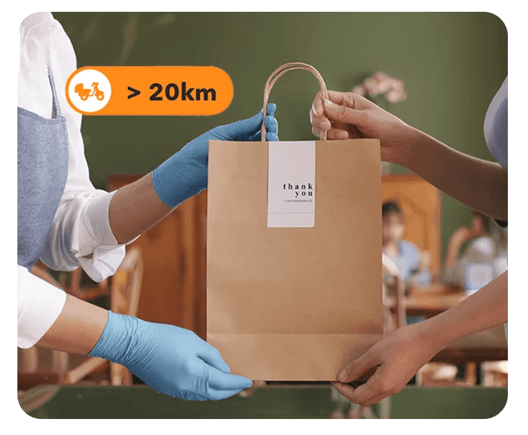 Malaysian F&B staff handing over a takeaway order prepared through StoreHub online ordering with extended delivery coverage.