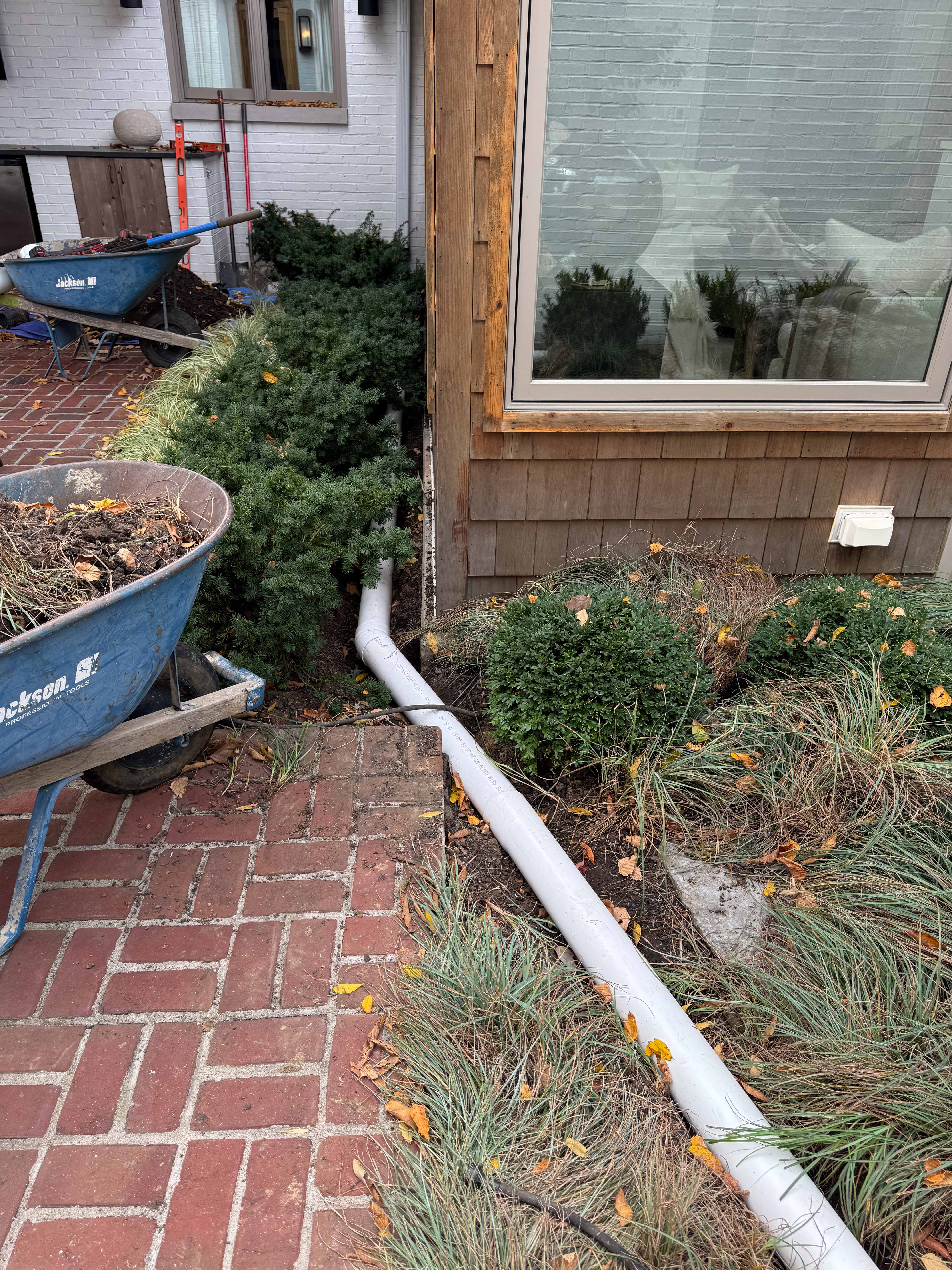 Front yard landscaping with mulch, shrubs, and brick pavers