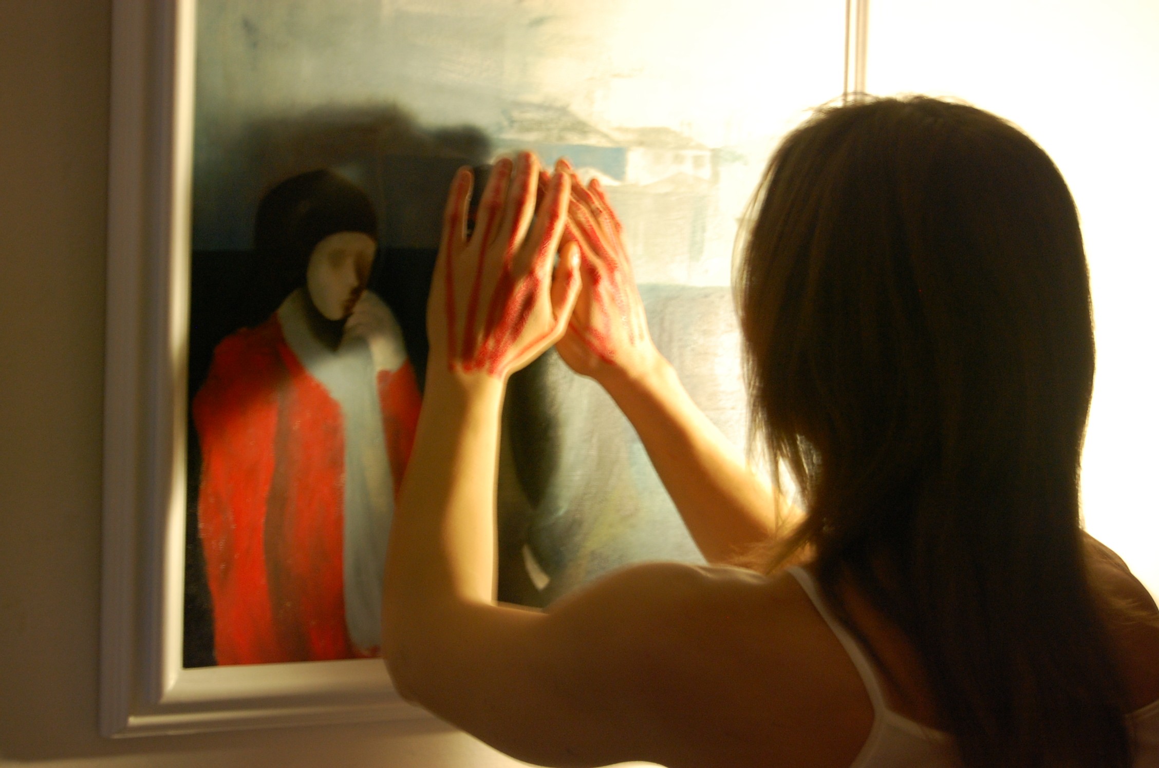 Ilaria solari di spalle tocca un dipinto con le mani dipinte di rosso durante la performance il bianco e il rosso