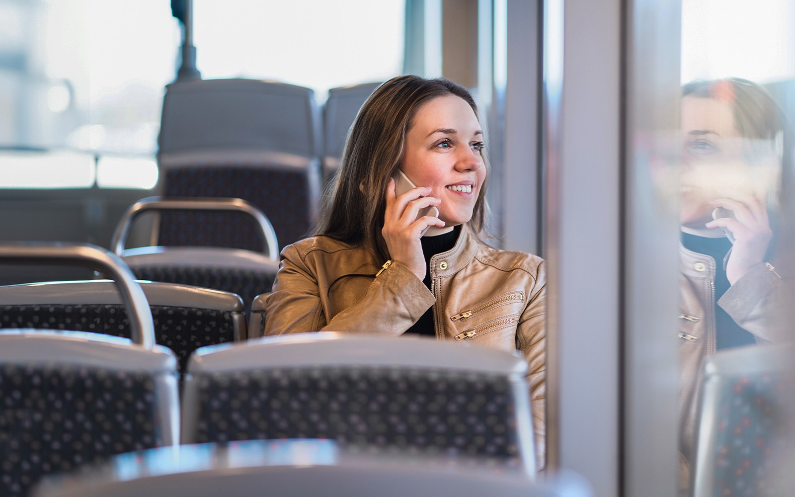 Passenger talking on phone inside airport transfer bus, Palermo.