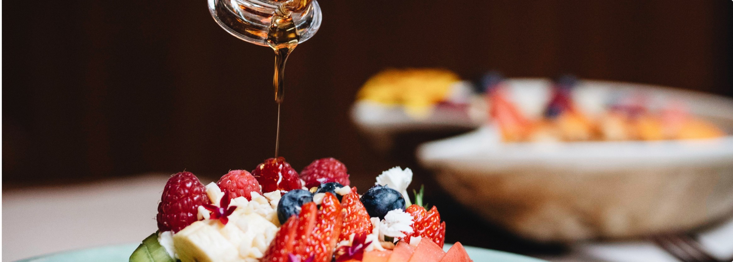 Maple syrup drizzled over fresh berries — vegetarian brunch at Faire, Eixample