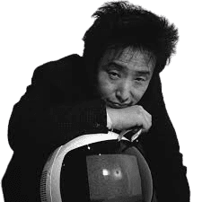 A black-and-white portrait of a man with messy, spiked hair, leaning thoughtfully on a retro-styled television set. Dressed in a dark suit, his pensive expression and the vintage TV screen, which displays a faint image, create a blend of modernity and nostalgia. The minimalist background draws attention to the unique combination of the man's creative personality and the old technology.