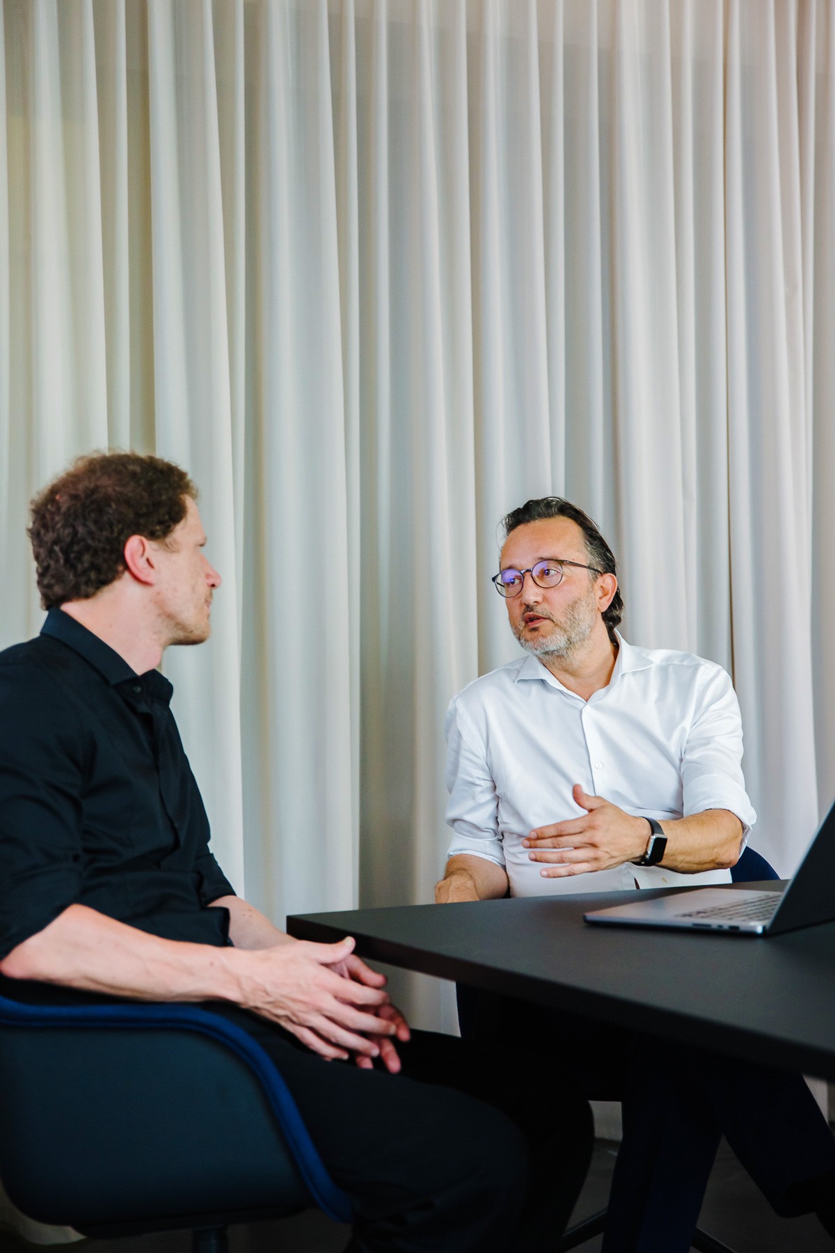In einem Konferenzraum im denkwerk sprechen Kaan Karaca (ETC. rechts) und Stephan Clasen (Technical Director) über KI-Einsatz im Mittelstand.