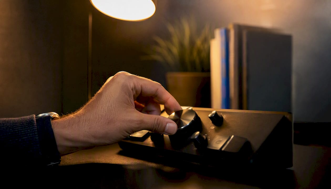 Hand adjusting dial on dark digital dashboard