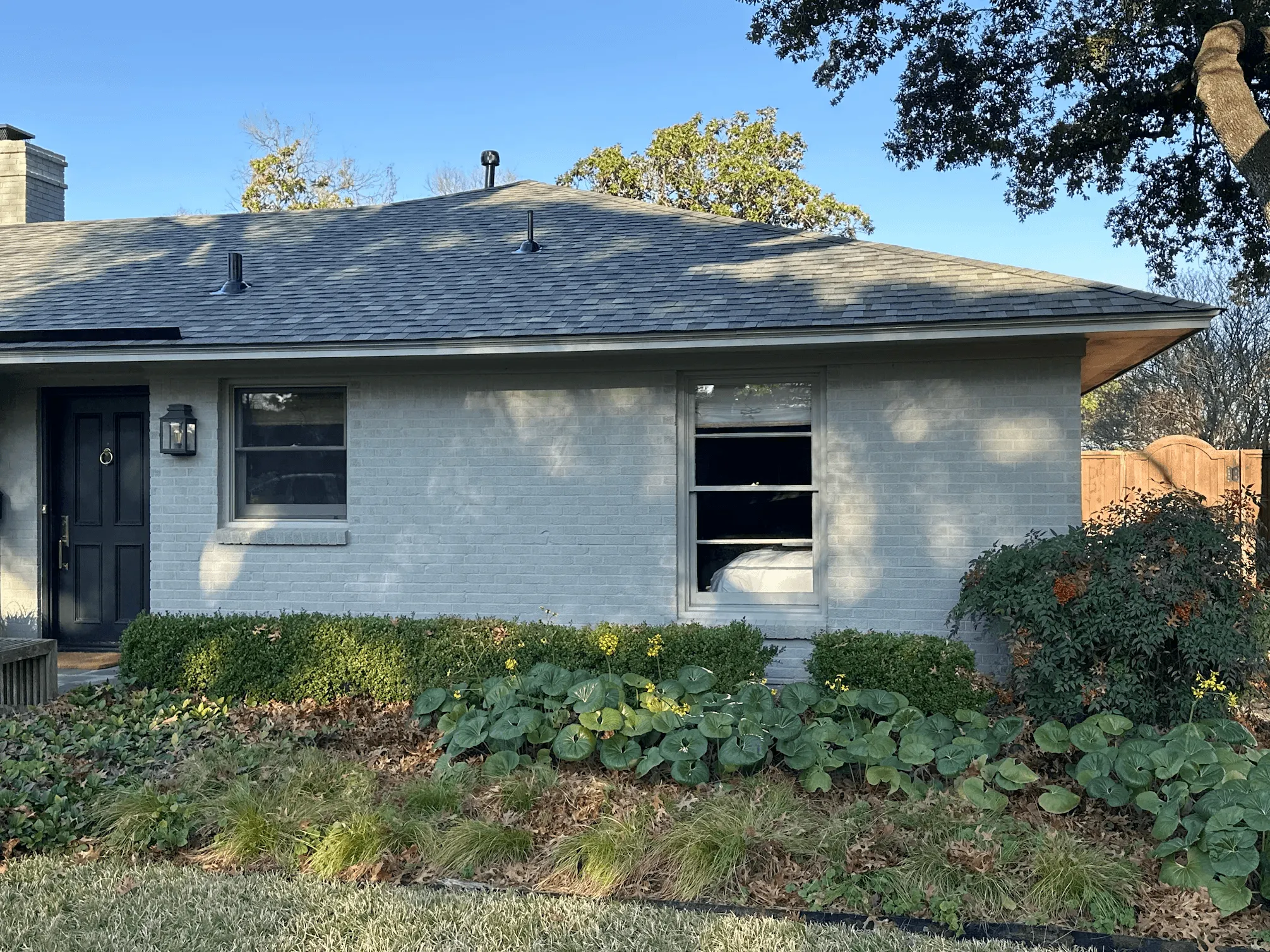 Front view of beautiful brick home in Corinth Texas featuring new F-Wave synthetic roof installation with mature landscaping
