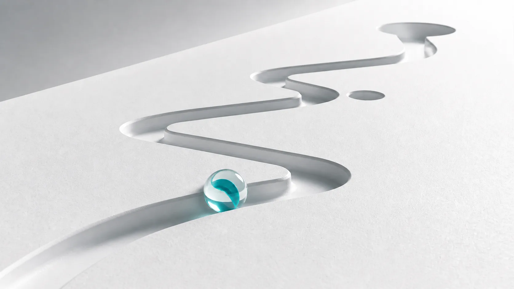 One GoMarble glass marble moving inside a recessed switchback route toward a terminal