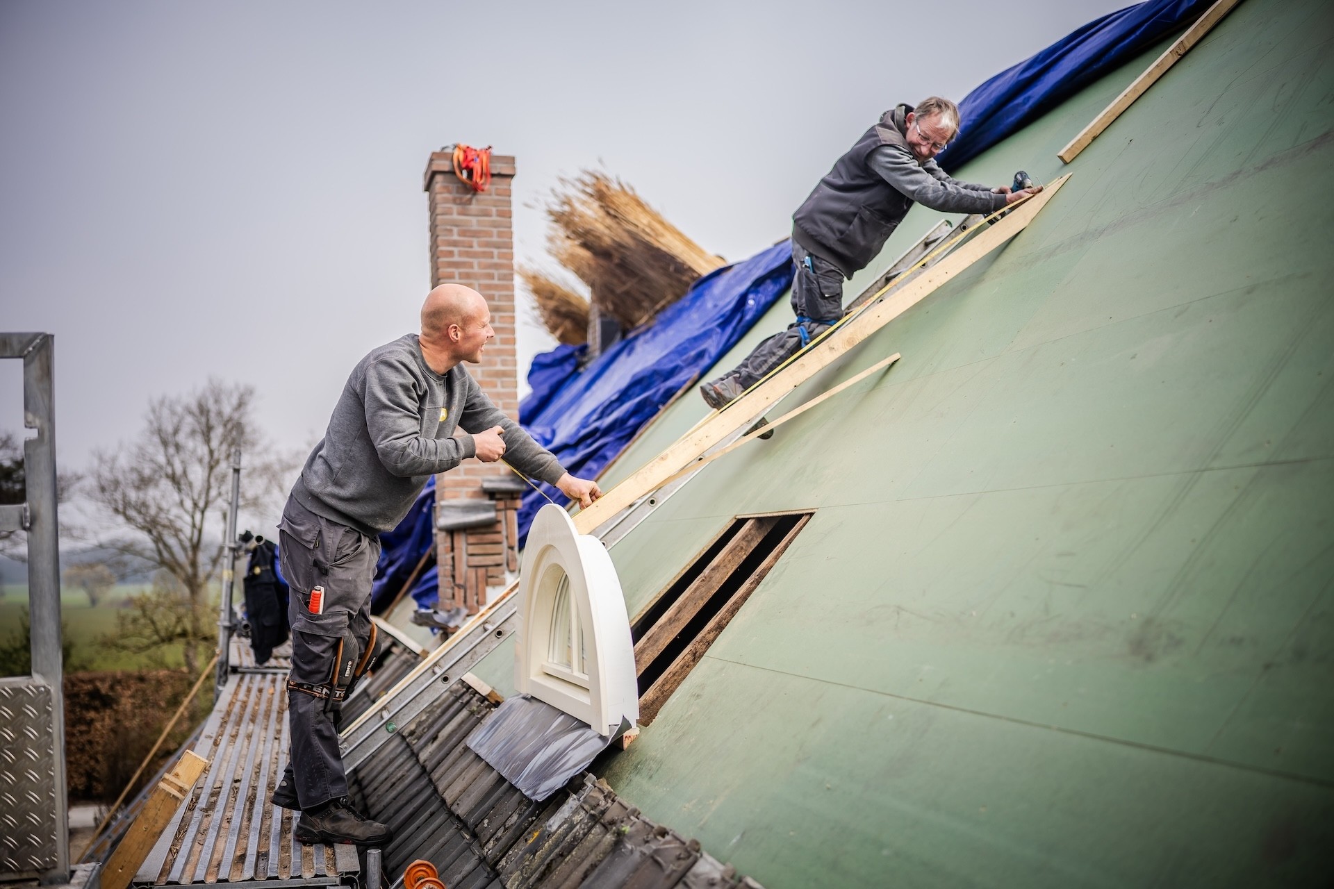 Rietdekker van Rietdekkersbedrijf van Dijk aan het werk