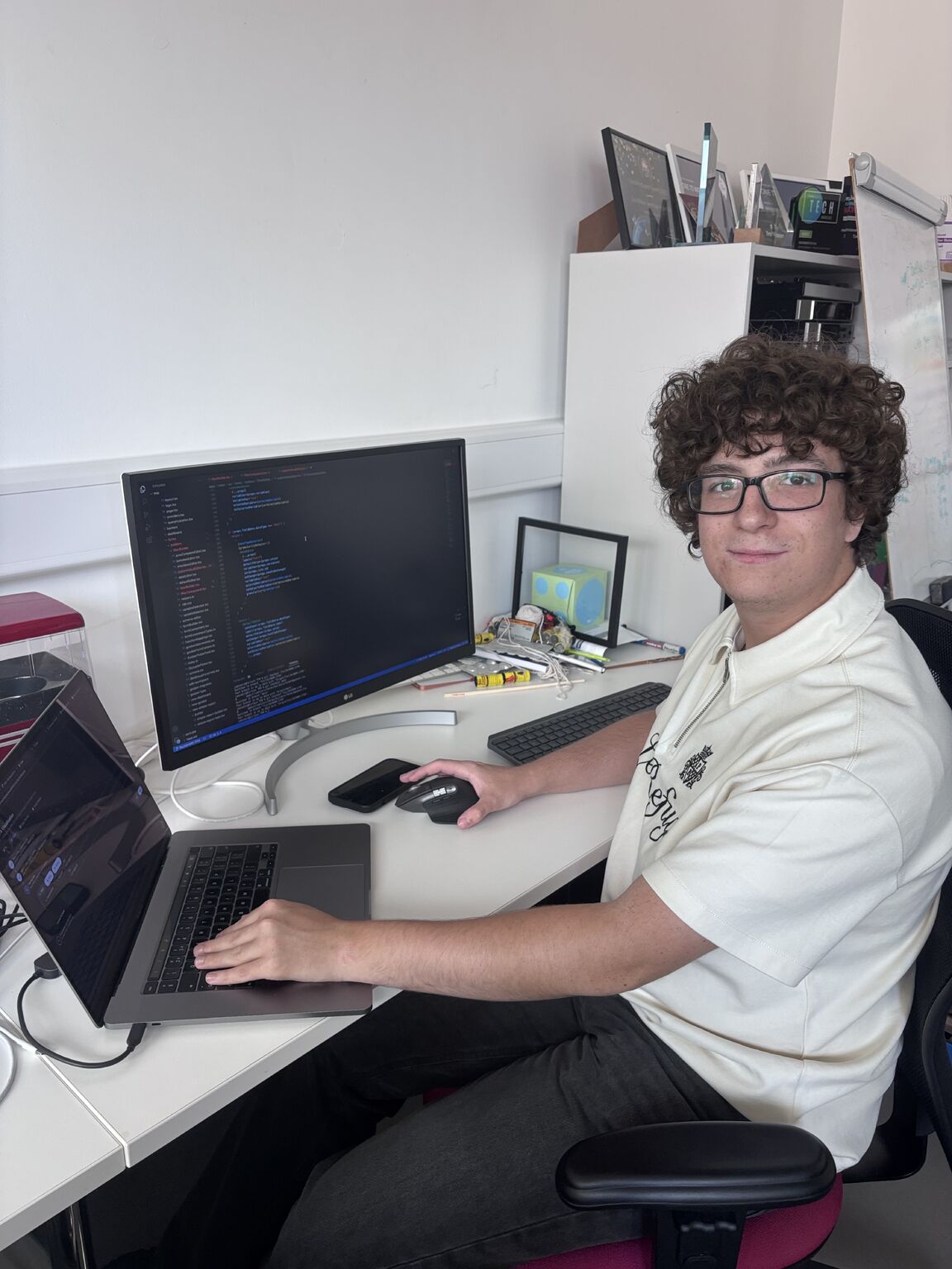 Jamie sat working at an office desk, turned facing the camera.