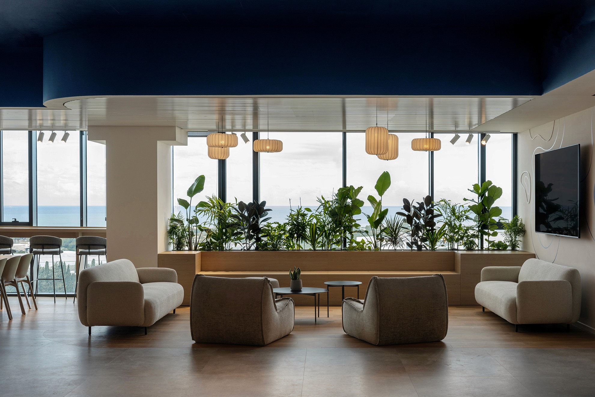 לאונג' מנוחה (Lounge Area) הצופה לנוף: הנמכת תקרה אקוסטית להגדרת אזור אינטימי בתוך ה-Open Space