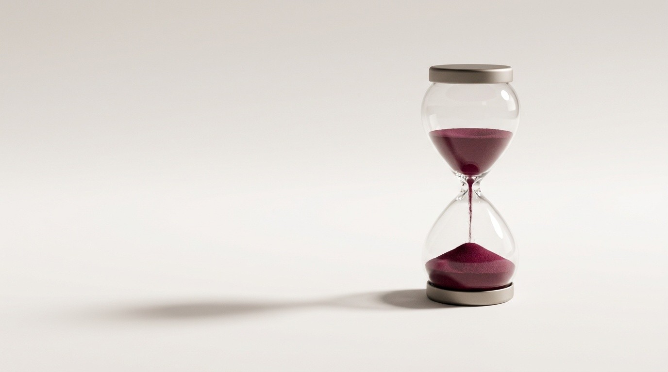 Hourglass with deep wine sand mid-flow, a measure of latency and time to go live on a phone deployment.